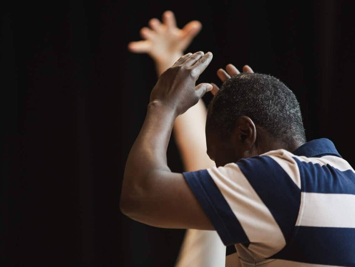 Man with hands over head | Collective Identity