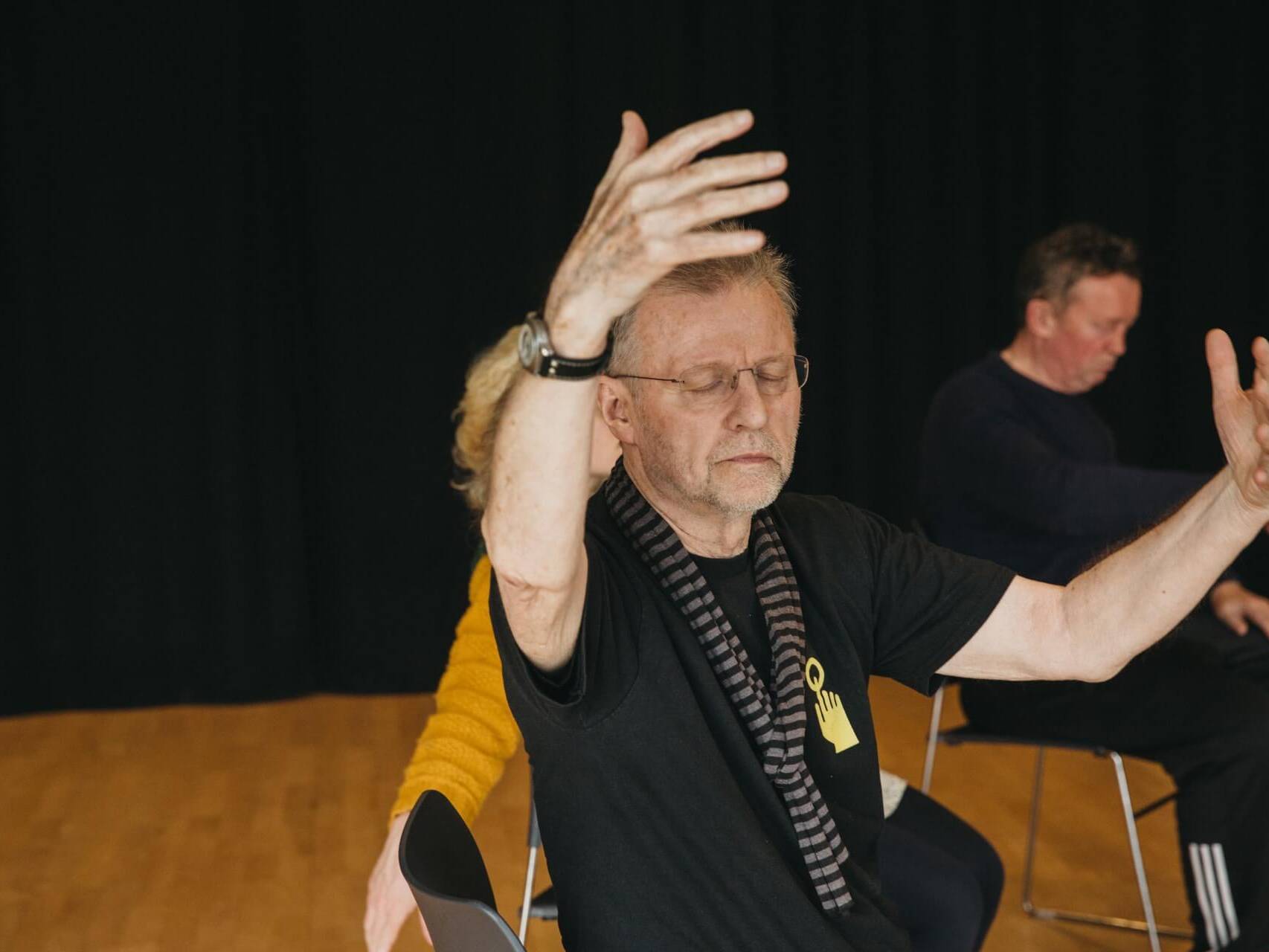 Collective Identity - man with eyes closed and hands in the air